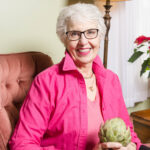 Judy in pink holding an artichoke